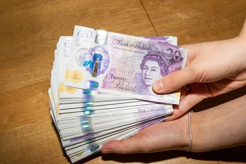 Stack of Twenty-Pound Banknotes Held in Hand 스톡 사진