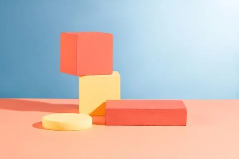 A stack of two cube podium arranged with round and rectangle podiums over blu Stock Photos