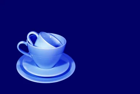 Stack of two different size of light blue coffee cup sets in blue background Stock Photos