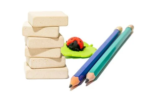 Stack of uniform rectangular stationery erasers, two pencils and eraser for k Stock Photos