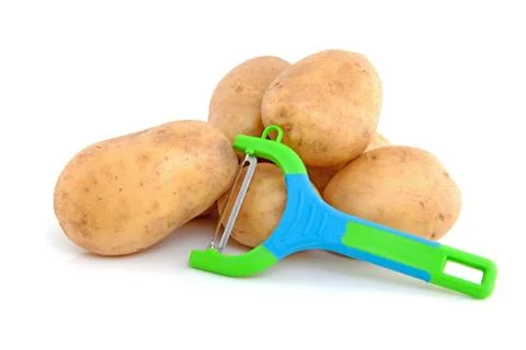 Stack of unpeeled potatoes and peeling knife Stock Photos