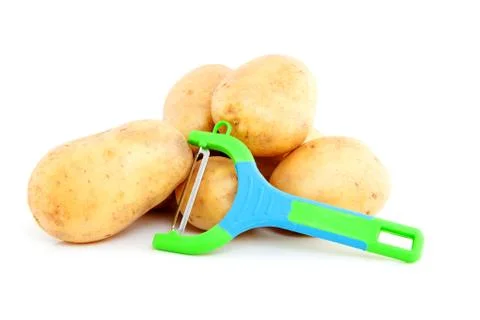 Stack of unpeeled potatoes with colorful peeling knife Stock Photos