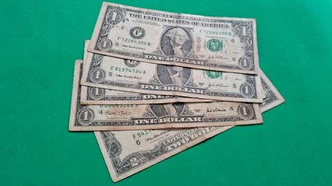 Stack of US dollar bills on vibrant green surface. Close-up financial cash money Stock Photos