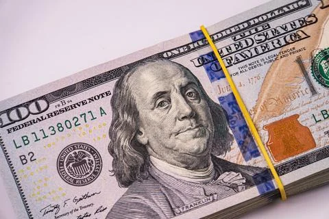 Stack of us dollars, bundled with rubber band, detailed portrait of benjamin  Photos