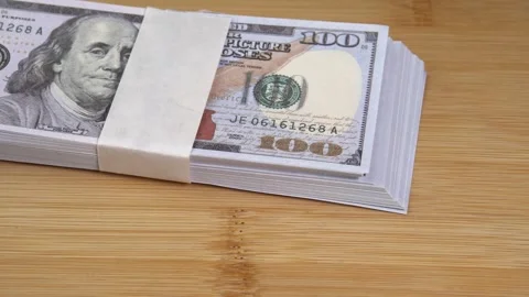 Stack of US dollars falls on the table. Counterfeiters check banknotes. Fight Stock Footage 246519079