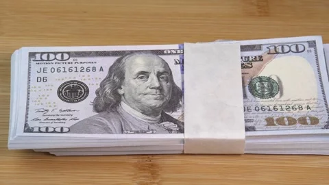 Stack of US dollars falls on the table. Counterfeiters check banknotes. Fight Stock Footage 246519130