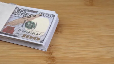 Stack of US dollars falls on the table. Counterfeiters check banknotes. Fight Stock Footage 246519143