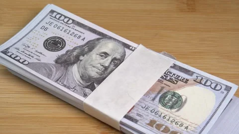 Stack of US dollars falls on the table. Counterfeiters check banknotes. Fight Stock Footage 246519161