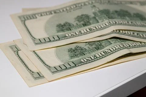 Stack of US one hundred dollar bills on white surface Stock-Fotos