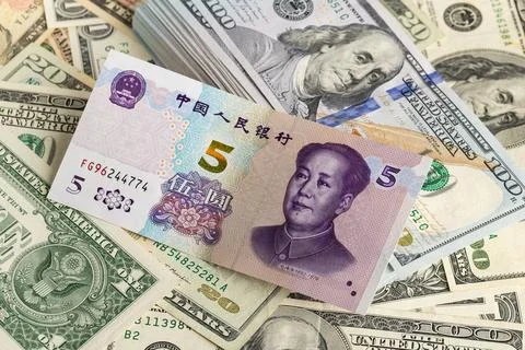 Stack of US One Hundred Dollar Bills Layered with Chinese Five Yuan Banknote Stock Photos