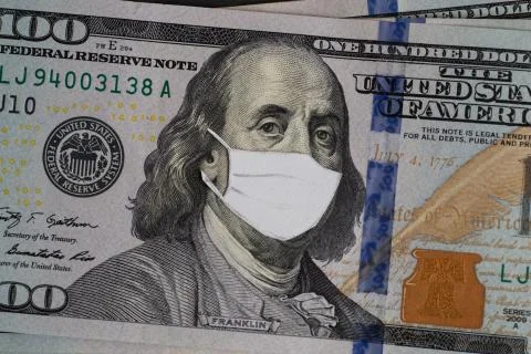 Stack of USA dollars banknotes with protective mask on it Stock Photos