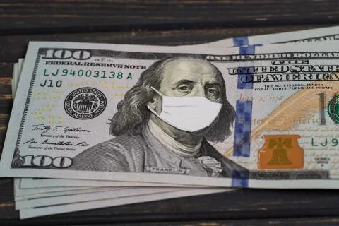 Stack of USA dollars banknotes with protective mask on it Stock Photos