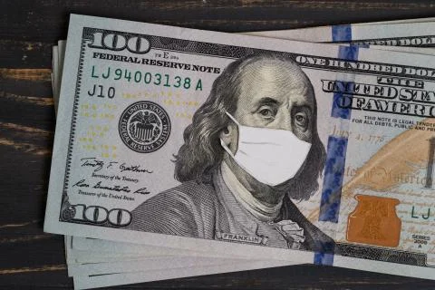 Stack of USA dollars banknotes with protective mask on it Stock Photos