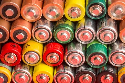 Stack of used batteries on a red background Stock Photos