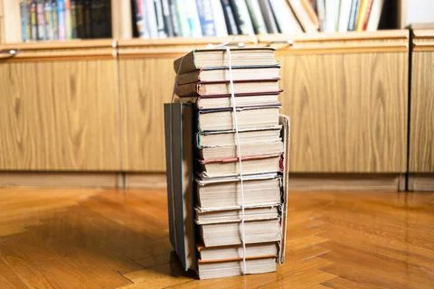 Stack of used books tied with packthread on floor Stock Photos