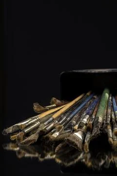 Stack of used paint brushes spilled from artist's box. Stock Photos
