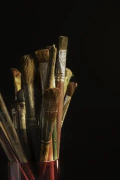 Stack of used painting brushes placed in red glass. Stock Photos