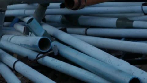 Stack of Used White and Blue PVC Pipes Видео 330319750