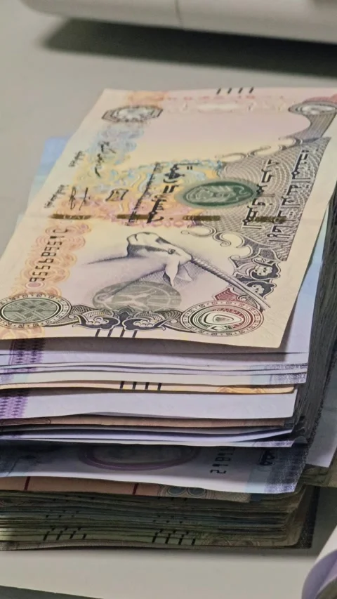Stack of various banknotes on a desk with a blurred office background, symbol 스톡 동영상 334152259