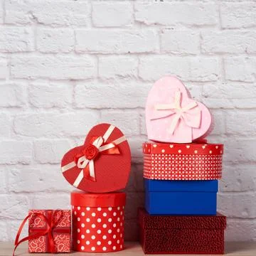 Stack of various boxes with gifts on white brick background 스톡 사진