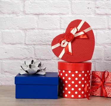 Stack of various boxes with gifts on white brick background 스톡 사진