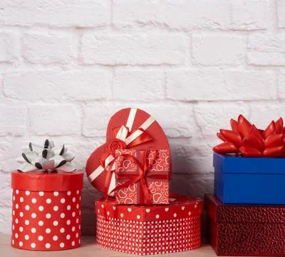 Stack of various boxes with gifts on white brick background Foto stock
