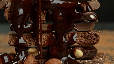 Stack of various chocolate pieces and nuts. High quality UHD shot. Video stock 93867424