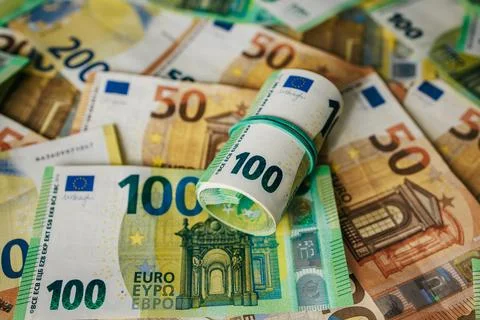 Stack of various Euro banknotes with a rolled 100 note secured by a rubber .. 스톡 사진