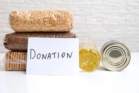 A stack of various packages of food for donation on white background, helping Stock Photos