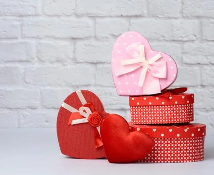 Stack of various red boxes with gifts on white brick background 스톡 사진