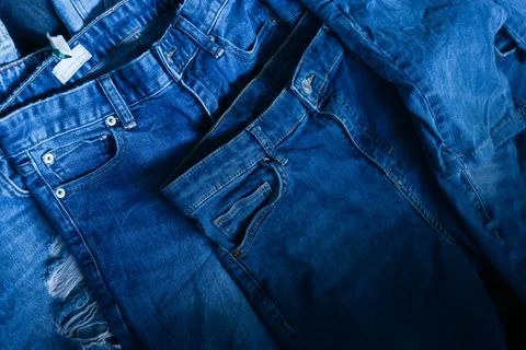 Stack of various shades blue jeans. Pile Blue denim jeans texture banner. Can Foto stock