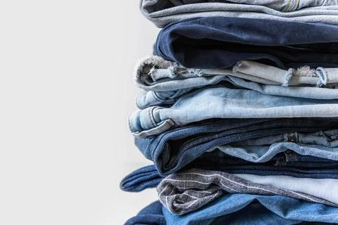 Stack of various shades of blue jeans on white background Stock Photos