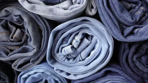 Stack of Various Shades of Rolled Up Denim Jeans	 Stock Footage 203961496