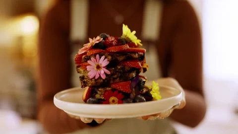Stack of vegan pancakes with fresh berries and edible flowers. Stock Footage 346400455