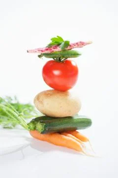 A stack of vegetables consisting of carrots, courgettes, a potato, a tomato, a 스톡 사진