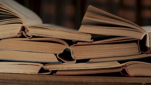 Stack of Vintage Open Books on Wooden Table in Cozy Library Interior Stock Footage 346062085