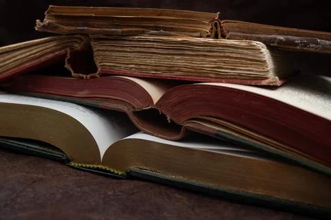 Stack of vintage opened books on leather desk, vignette soft focus close up Foto stock