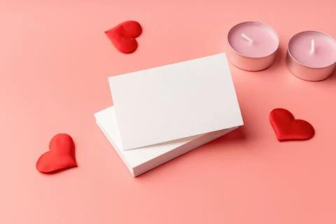 Stack of visit cards on pink background with hearts and candles Foto stock