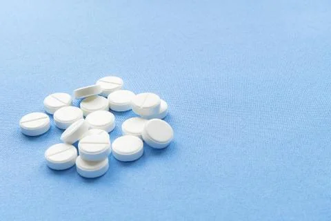 A stack of vitamin and mineral  tablets isolated on a blue background. Stock Photos