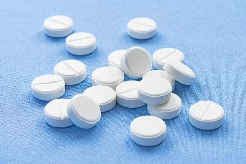 A stack of vitamin and mineral  tablets isolated on a blue background. Foto stock