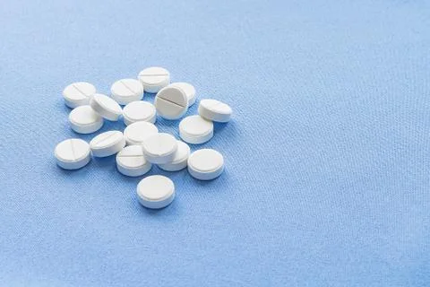 A stack of vitamin and mineral  tablets isolated on a blue background. Foto stock
