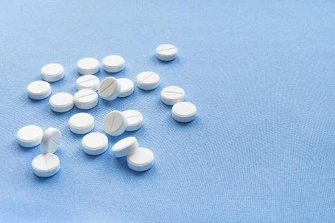 A stack of vitamin and mineral  tablets isolated on a blue background. Foto stock