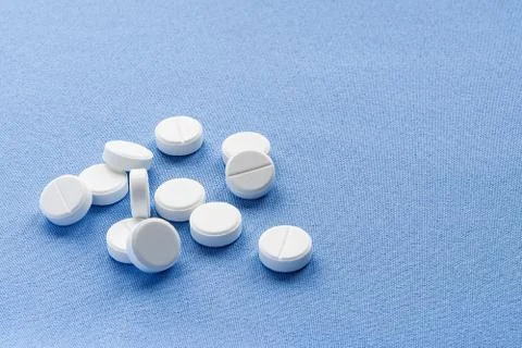 A stack of vitamin and mineral  tablets isolated on a blue background. Foto stock