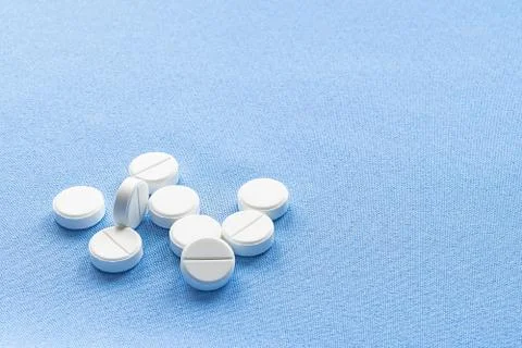 A stack of vitamin and mineral  tablets isolated on a blue background. Stock Photos
