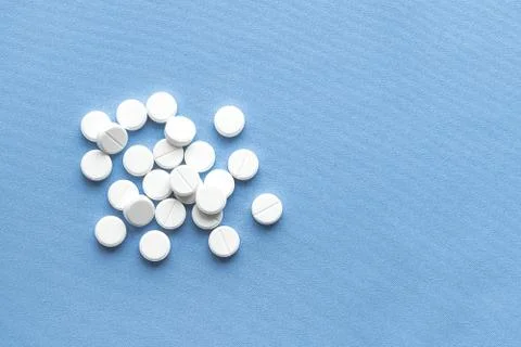 A stack of vitamin and mineral  tablets isolated on a blue background. Foto stock