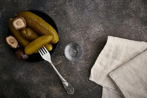 A stack of vodka, pickles and mushrooms on a saucer, top view, close-up Stock Photos