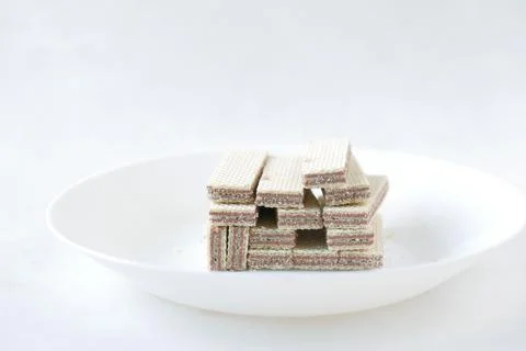 Stack of wafer roll chocolate on a plate on white background 写真素材