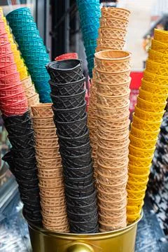 Stack of waffle cones of different colors, pink, black and brown for ice crea Stock Photos