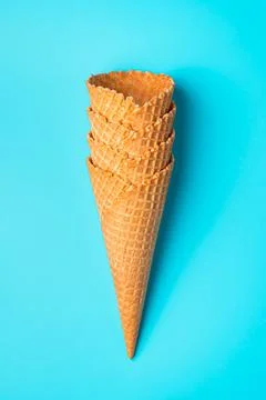 A stack of waffle cones for ice cream on a blue background. Fotos de archivo