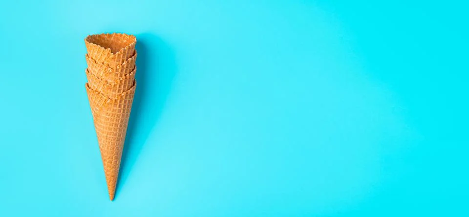 A stack of waffle ice cream cups on a light blue background. Fotos de archivo
